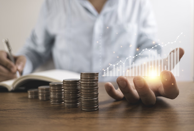businessman holding virtual graph writing saving dividend profit notebook with coins stacking business investment saving profit concept 50039 1548